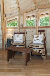 Habitación de madera con 2 sillas y mesa de madera. en La Batelière sur Loire en La Chapelle-aux-Naux