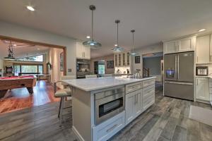 cocina con armarios blancos y mesa de billar en Serene Riverfront Home with Torch Lake Access!, en Rapid City