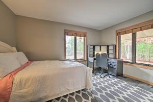 1 dormitorio con 1 cama, escritorio y ventanas en Serene Riverfront Home with Torch Lake Access!, en Rapid City