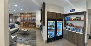 a living room with a refrigerator with drinks in it at Holiday Inn Express & Suites Marquette, an IHG Hotel in Marquette
