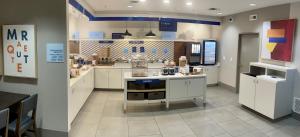 a large kitchen with white cabinets and a counter at Holiday Inn Express & Suites Marquette, an IHG Hotel in Marquette