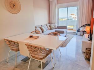 een woonkamer met een tafel en stoelen en een bank bij Seaview Penthouse Valle Romano Golf in Estepona