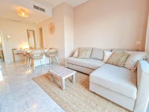 a living room with a couch and a table at Seaview Penthouse Valle Romano Golf in Estepona