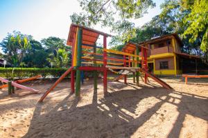 un parque infantil en la arena frente a una casa en IPÊ Florido Parque Hotel en Paracatu