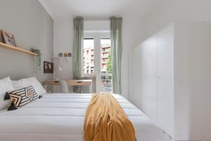 a bedroom with a large white bed with a large window at Top Living Apartments - Carducci in Turin