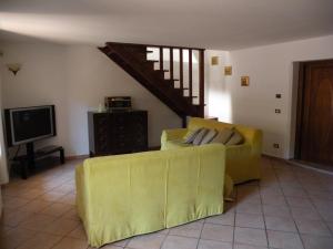 sala de estar con sofá amarillo y TV en Villa Carlotta, en Isernia