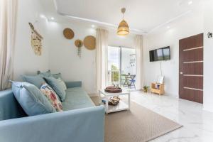 a living room with a blue couch and a tv at Larimar 302 - Bayahibe in Bayahibe