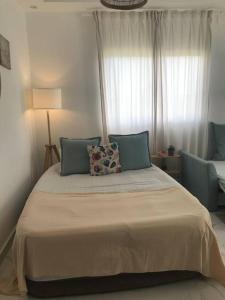 ein Schlafzimmer mit einem großen Bett mit blauen Kissen in der Unterkunft Larimar 302 - Bayahibe in Bayahibe