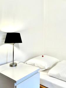Un dormitorio con una cama y una lámpara en un escritorio. en Villa Bergruh, en St. Gallen