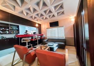 um bar com um balcão vermelho e cadeiras vermelhas em Medallion Hotels em Lagos