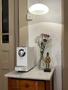 a table with a microwave and a vase of flowers at Villa Bergruh in St. Gallen