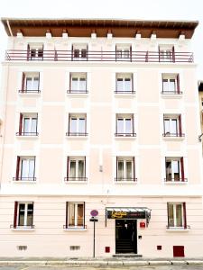 - un bâtiment blanc avec une porte devant dans l'établissement Hôtel Gloria, à Grenoble