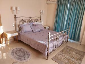Un dormitorio con una cama grande con sábanas y almohadas púrpuras. en Elegant View - Trikala - 3BD Apt, en Tríkala