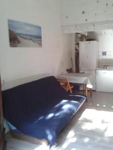 a bedroom with a blue bed and a refrigerator at A Deux Pas du Courant in Mimizan-Plage