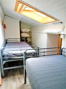 two beds in a small room with a ceiling at A Deux Pas du Courant in Mimizan-Plage