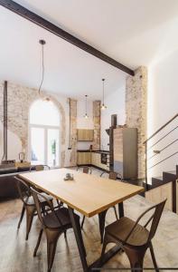 cocina y comedor con mesa de madera y sillas en Apartamentos BocairentHomes, disfruta en pleno centro de Bocairent, en Bocairent