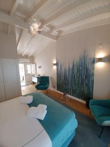 a bedroom with a large bed and two green chairs at Villa Zawaia B&B in Lagos +37 photos