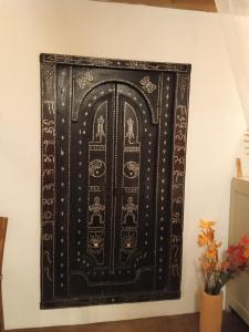 una imagen de una puerta negra en una pared en chez Karine en Ceyzérieu