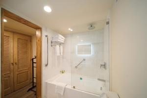 a white bathroom with a tub and a shower at Real Intercontinental San Salvador, an IHG Hotel in San Salvador