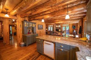 cocina grande con suelo y techo de madera en Luxe Log cabin with hot tub/spa/steam room!, en Wilmington