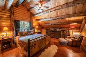 1 dormitorio en una cabaña de madera con 1 cama y 1 silla en Luxe Log cabin with hot tub/spa/steam room!, en Wilmington
