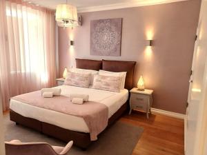 a bedroom with a large bed and a chandelier at Villa Zawaia B&B in Lagos
