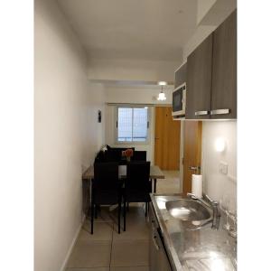 a kitchen with a sink and a table in a room at Shanti Alojamiento Monoambiente y Departamento in Mendoza