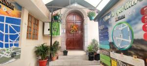 un edificio con una puerta de madera con plantas. en Minka Hostel, en Quito