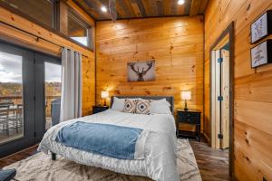 a bedroom with a bed in a room with wooden walls at The Overlook - '21 Cabin - Gorgeous Unobstructed Views - Fire Pit Table - GameRm - HotTub - Xbox - Lots of Bears in Gatlinburg