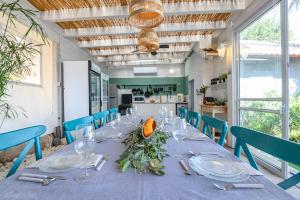 a long table with a blue table cloth and blue chairs at Kamaya Suites in Kinneret