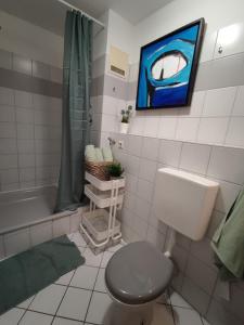 uma casa de banho com um WC, um lavatório e uma banheira em ZEN Apartment - good traffic connection - bright em Karlsruhe