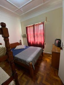 a bedroom with a bed and a red window at Pousada J.C. Cazeri in Santos