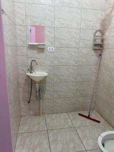 a bathroom with a sink and a mop at Pousada J.C. Cazeri in Santos