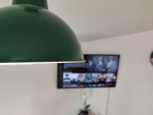 a green lamp with a tv in a room at ZEN Apartment - good traffic connection - bright in Karlsruhe