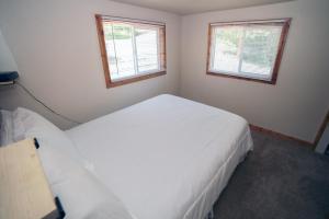 a bedroom with two white beds and two windows at Ponderosa Lodge in Estes Park