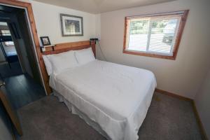 un letto bianco in una camera da letto con finestra di Ponderosa Lodge a Estes Park