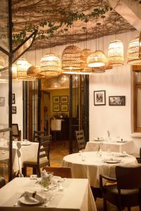 una sala da pranzo con tavoli bianchi e lampadari a braccio di Dar Tanja Boutique Hotel a Tangeri