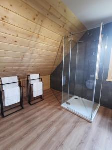 une chambre avec deux chaises blanches et une douche dans l'établissement Predlówka - Na dachu Świata, à Zawoja