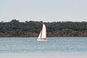 a small sail boat on a large body of water at Khaban Bacalar Hotel Boutique in Bacalar