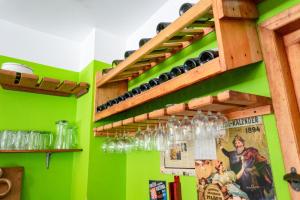 a room with green walls and shelves with wine glasses at Hotel Boutique Hurvínek in Montañita