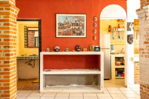 une cuisine avec un mur rouge et une table blanche dans l'établissement Casa Madero, à Oacalco
