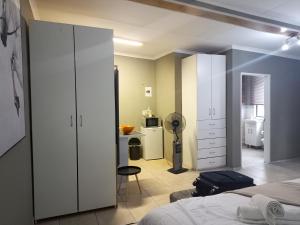 a bedroom with a bed and a room with a kitchen at Menlyn Mews Guesthouse in Pretoria +148 photos