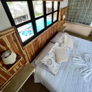 een slaapkamer met een bed en uitzicht op een zwembad bij Johnnys Place Hotel in Monterrico