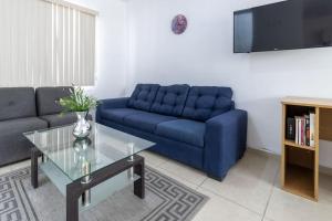 a living room with a blue couch and a glass table at Casa de lujo en Aguascalientes in Aguascalientes