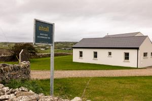 a sign in front of a white building at Aiteall Boutique Accommodation in Liscannor