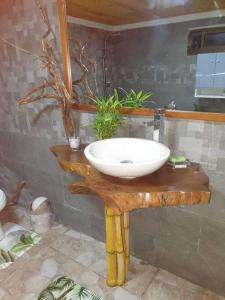 een badkamer met een witte wastafel op een houten tafel bij Ohana Location Ravissant appart spacieux parking gratuit à uturoa in Uturoa
