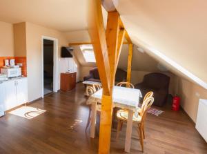 a living room with a table and chairs and a staircase at Vár-Liget Vendégház in Kisnána