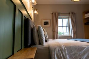 1 dormitorio con cama y ventana en Aiteall Boutique Accommodation, en Liscannor