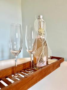 two wine glasses and a bottle on a shelf at Villa Bergruh in St. Gallen