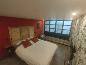 a bedroom with a white bed and a large window at L'Atelier in Saint-Laurent-Blangy